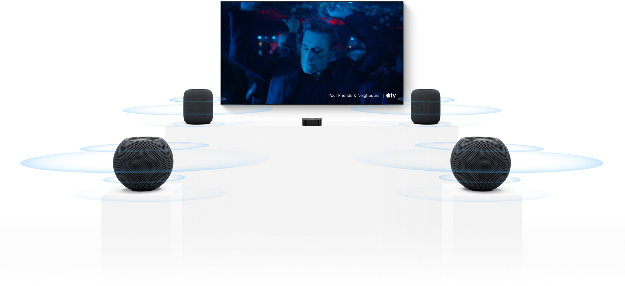 Apple TV 4K and HomePod: two HomePod speakers, one at each side of TV screen, two HomePod mini speakers in front, sound waves around each