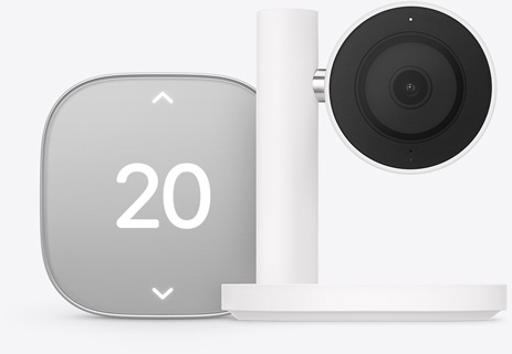 Apple Home Collection smart home thermostat, silver color, displaying temperature of 20 degrees Celsius, Apple Home Collection smart home camera, black lens and surround mounted on a white stand and arm