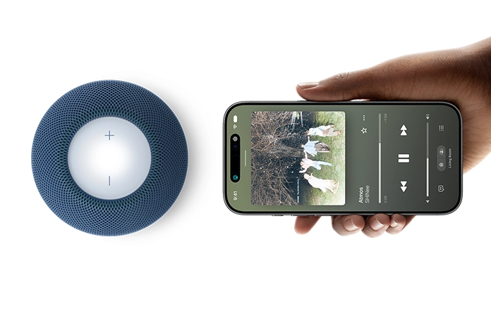 HomePod mini 2 and iPhone: A hand holds iPhone beside blue HomePod mini 2 for handoff feature