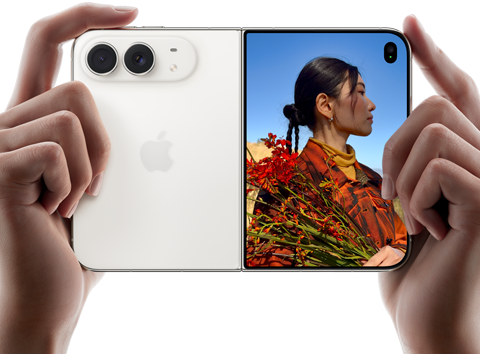 iPhone Duo, u boji sjajne zvijezde, drži se dvjema rukama u vodoravnoj orijentaciji, otvoren, lijevi panel prikazuje stražnje dvojne kamere Fusion od 48 MP, desni panel prikazuje osobu koja snima fotografiju na vanjskom zaslonu, objekt fotografije može vidjeti svoje lice dok se fotografija snima koristeći Duo Preview