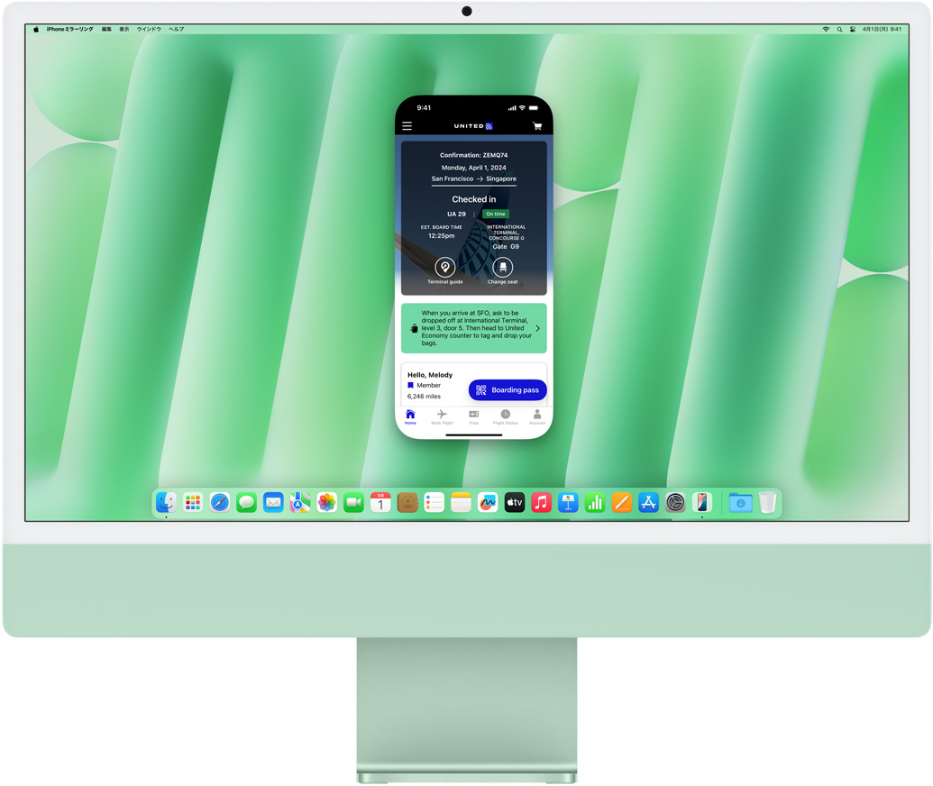 iPhoneミラーリング機能のデモ。UNITEDアプリを表示したiPhoneの画面がiMacにミラーリングされ、操作されている