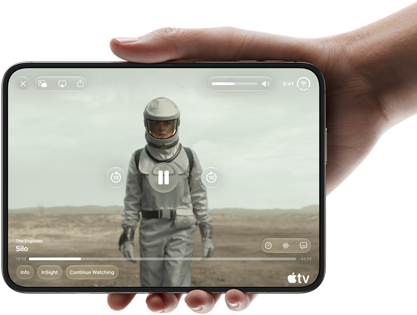 iPhone&nbsp;Duo, tiek turēts vienā rokā, atvērts horizontālā novietojumā, pilnībā atvērts, iekšējā ekrānā tiek demonstrēts Apple&nbsp;TV seriāls “Silo”
