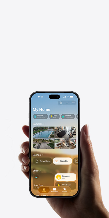 一隻手拿著 iPhone，螢幕顯示家居 app 的 My Home 檢視介面，展示攝影機畫面、場景設定和玄關設定。