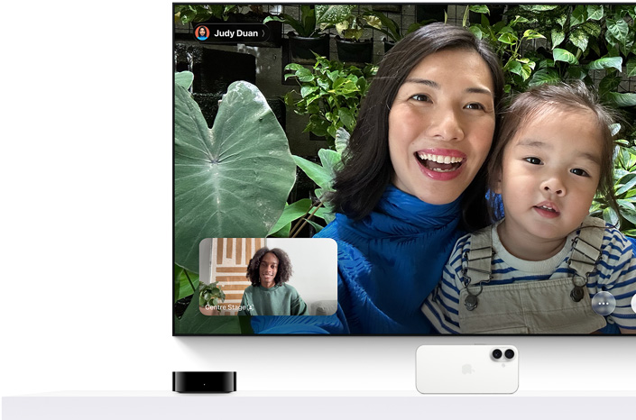 Apple TV 4K and iPhone: TV screen shows a FaceTime call, a person holds a young child, second caller in inset