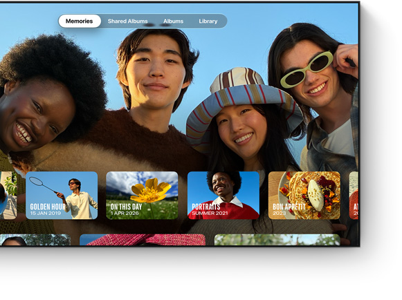 Photos app on TV screen, Memories tab selected, four people smiling, row of dated memory thumbnails below