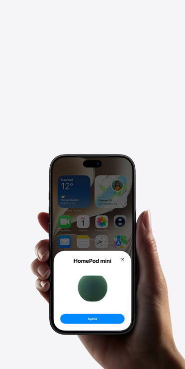 Bir elin tuttuğu iPhone ekranında Ev uygulamasında akıllı ev aksesuarı kurulumu bildirimi gösteriliyor