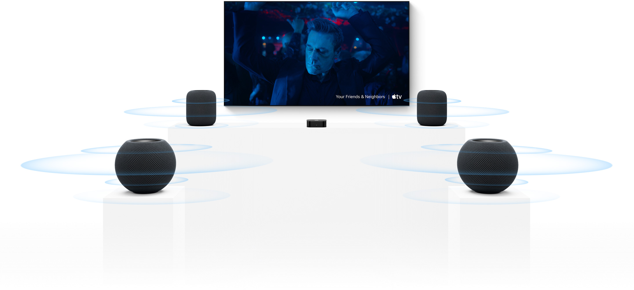 Apple TV 4K and HomePod: two HomePod speakers, one at each side of TV screen, two HomePod mini speakers in front, sound waves around each