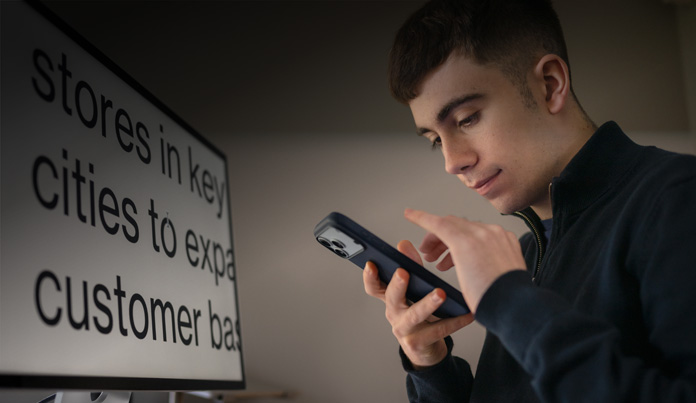 Un estudiante interactúa con su iPhone cerca de su rostro