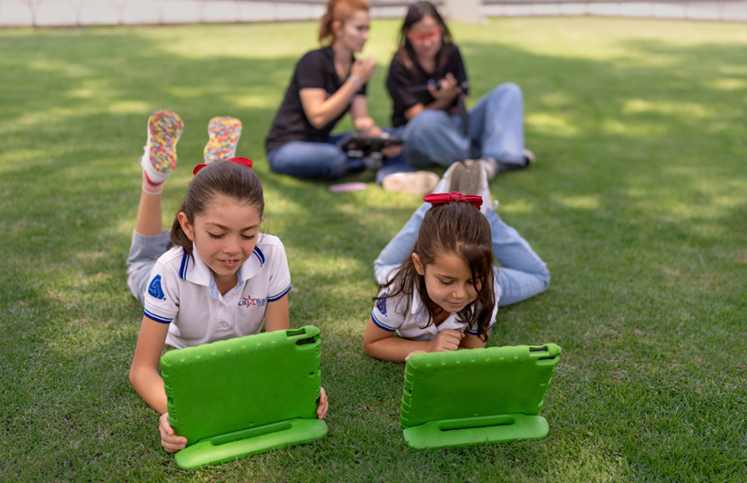 Ana Lilia Gómez Iniesta (ALC) supports teacher Eleane Ruth Guzmán Padilla while students work independently on a math lesson at Colegio Cristóbal Colón.