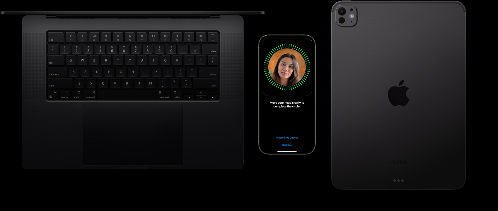 Ein MacBook in Space Schwarz, ein iPhone in Titan Natur und ein iPad in Space Schwarz liegen nebeneinander mit einem Face ID Setup auf dem iPhone