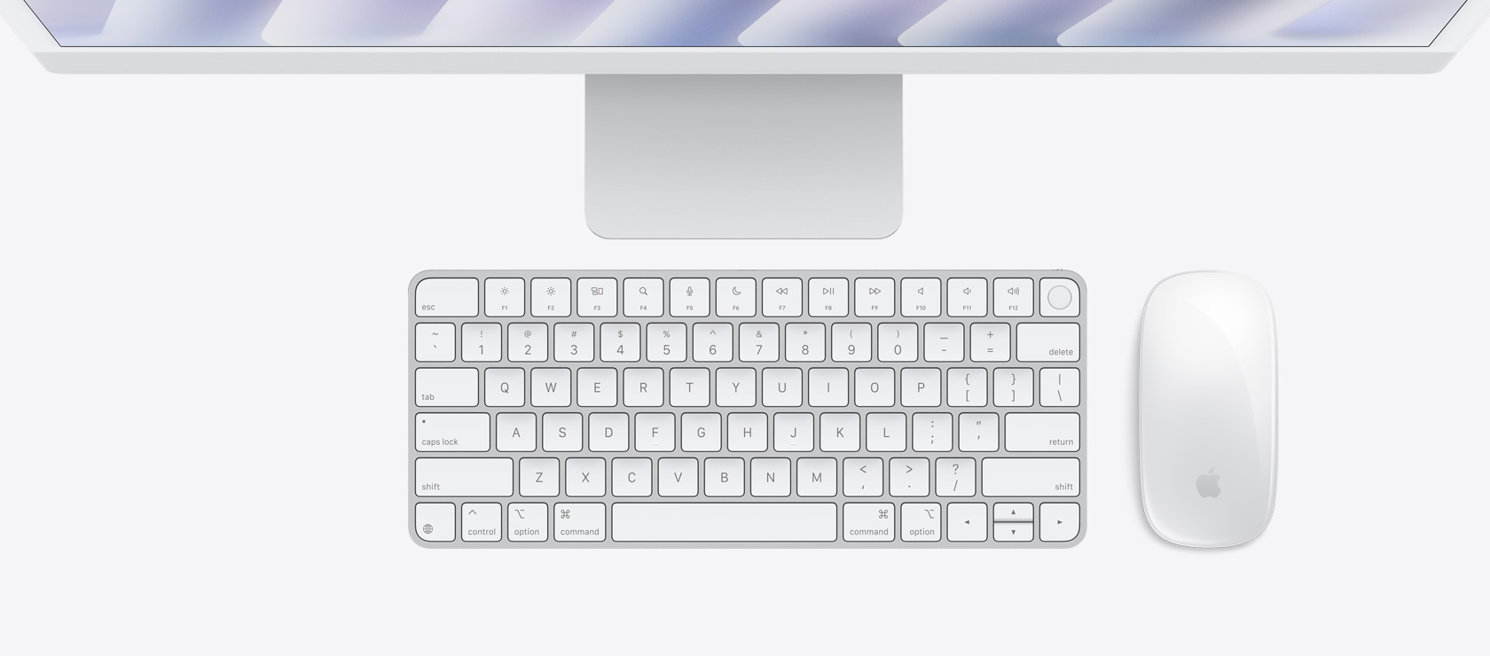 Hõbedane iMac ülalt alla vaates koos sama värvi hiire ja klaviatuuriga