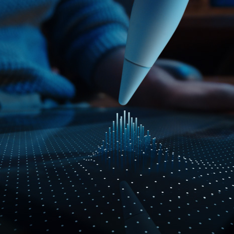 Apple Pencil Pro, blanc, la pointe survole l’écran d’un iPad affichant une grille de points dont certains se regroupent en colonnes vers la pointe de l’Apple Pencil Pro